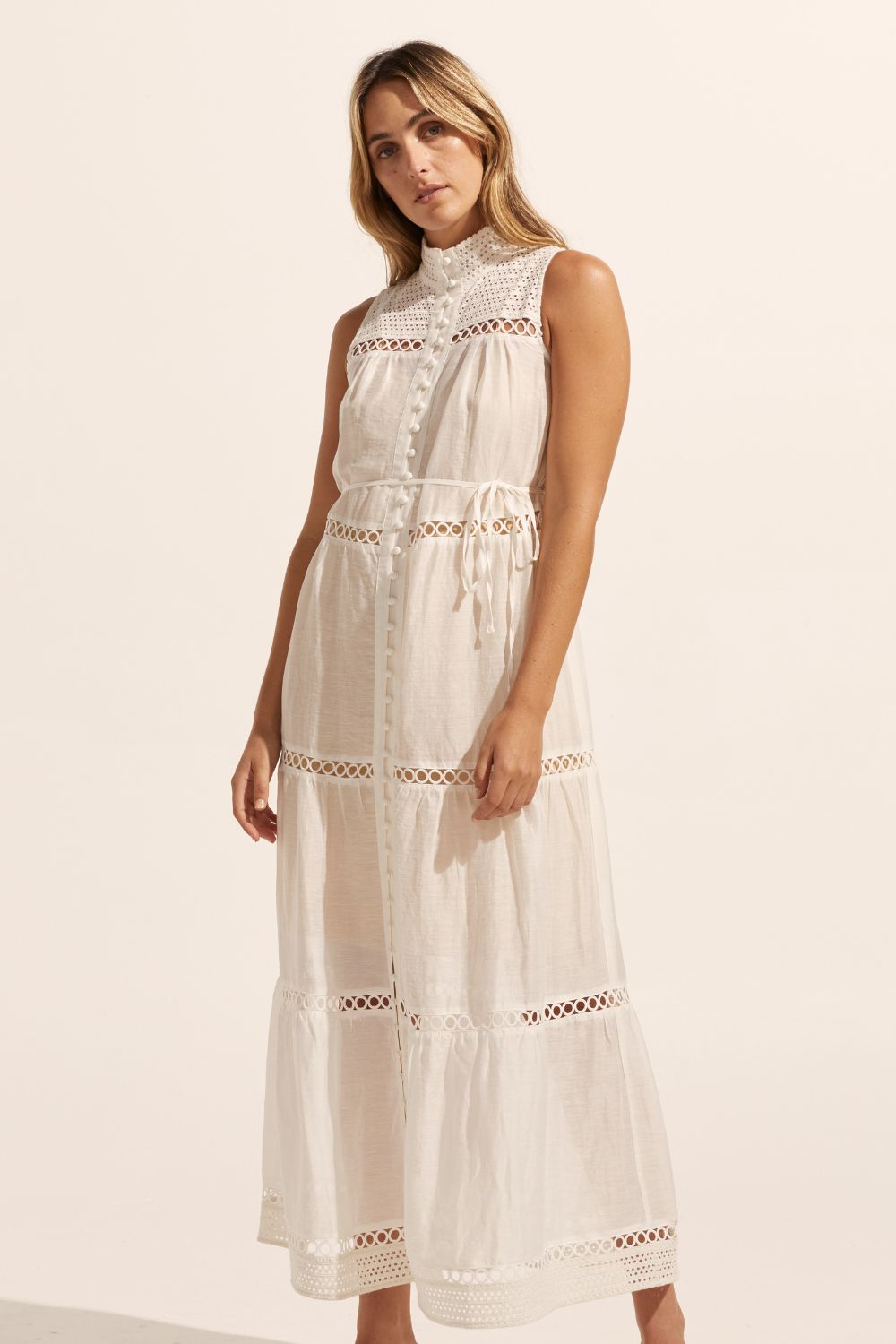 white, maxi dress, sleeveless, button down centre, high neck, circular lace design, self tie fabric belt, front image