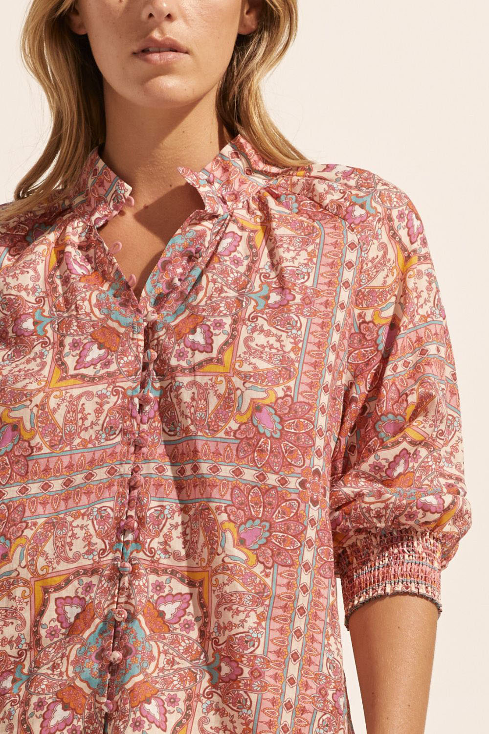 pink print, medium length sleeve, buttons down centre, small side splits, high neck, close up image
