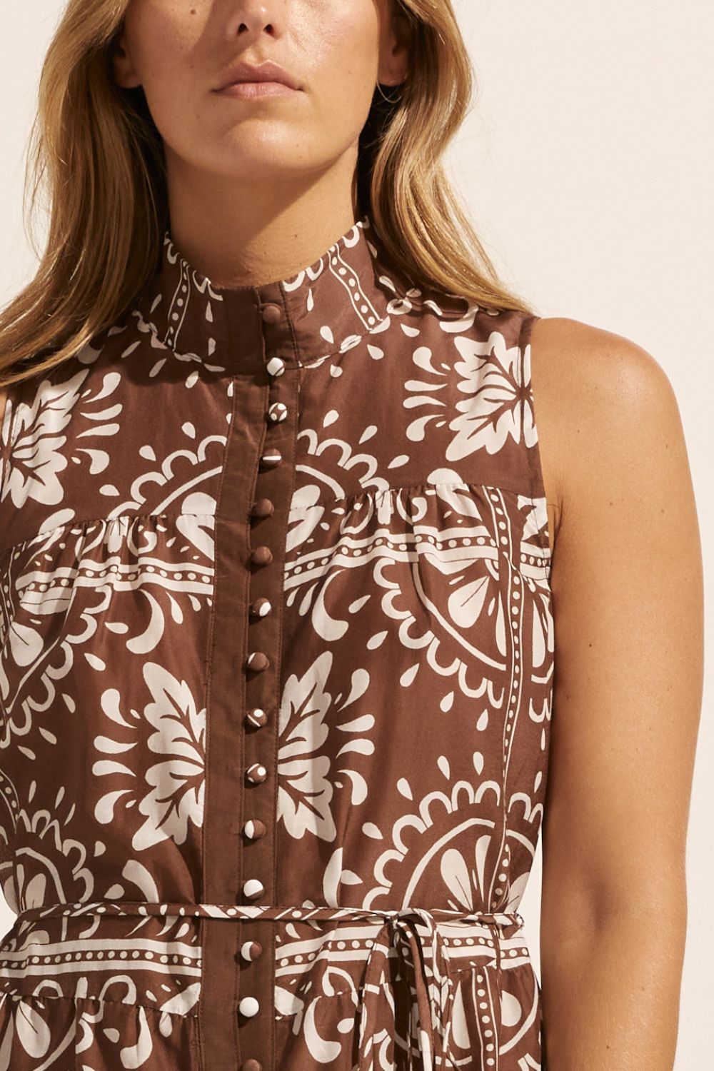 brown and white print, high neck, buttons down centre, thin fabric belt, sleeveless, dress, close up view