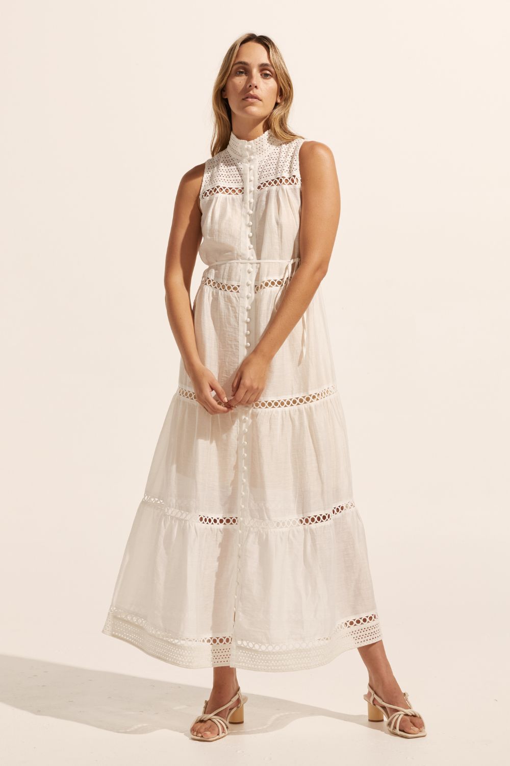 white, maxi dress, sleeveless, button down centre, high neck, circular lace design, self tie fabric belt, front image