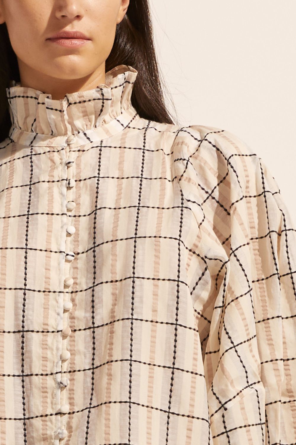 cream check print, covered buttons, voluminous sleeve, high neck, ruffle collar, mid length sleeve, elasticated cuff, top, close up image
