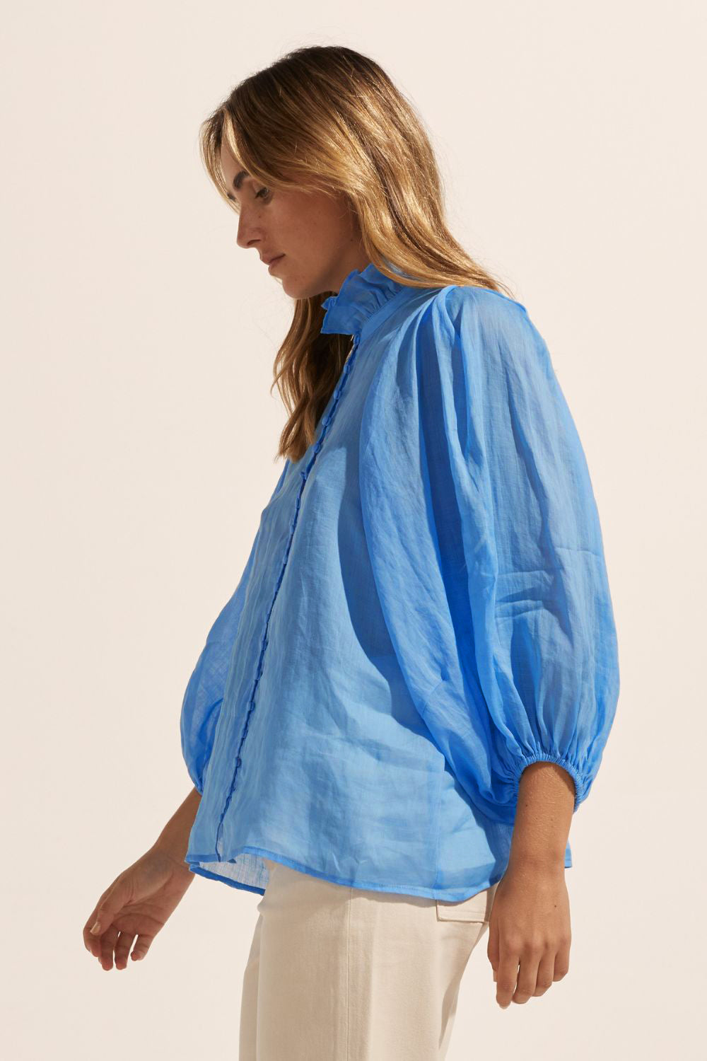 blue, ruffle neck collar, buttons down centre, mid length sleeve, shirt, side view