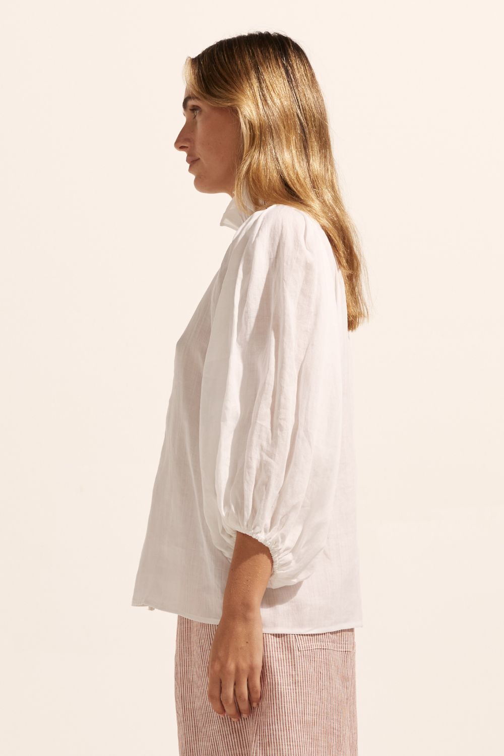 white, ruffle neck collar, buttons down centre, mid length sleeve, shirt, side view
