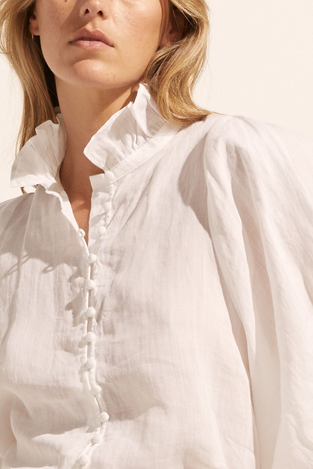 white, ruffle neck collar, buttons down centre, mid length sleeve, shirt, close up view