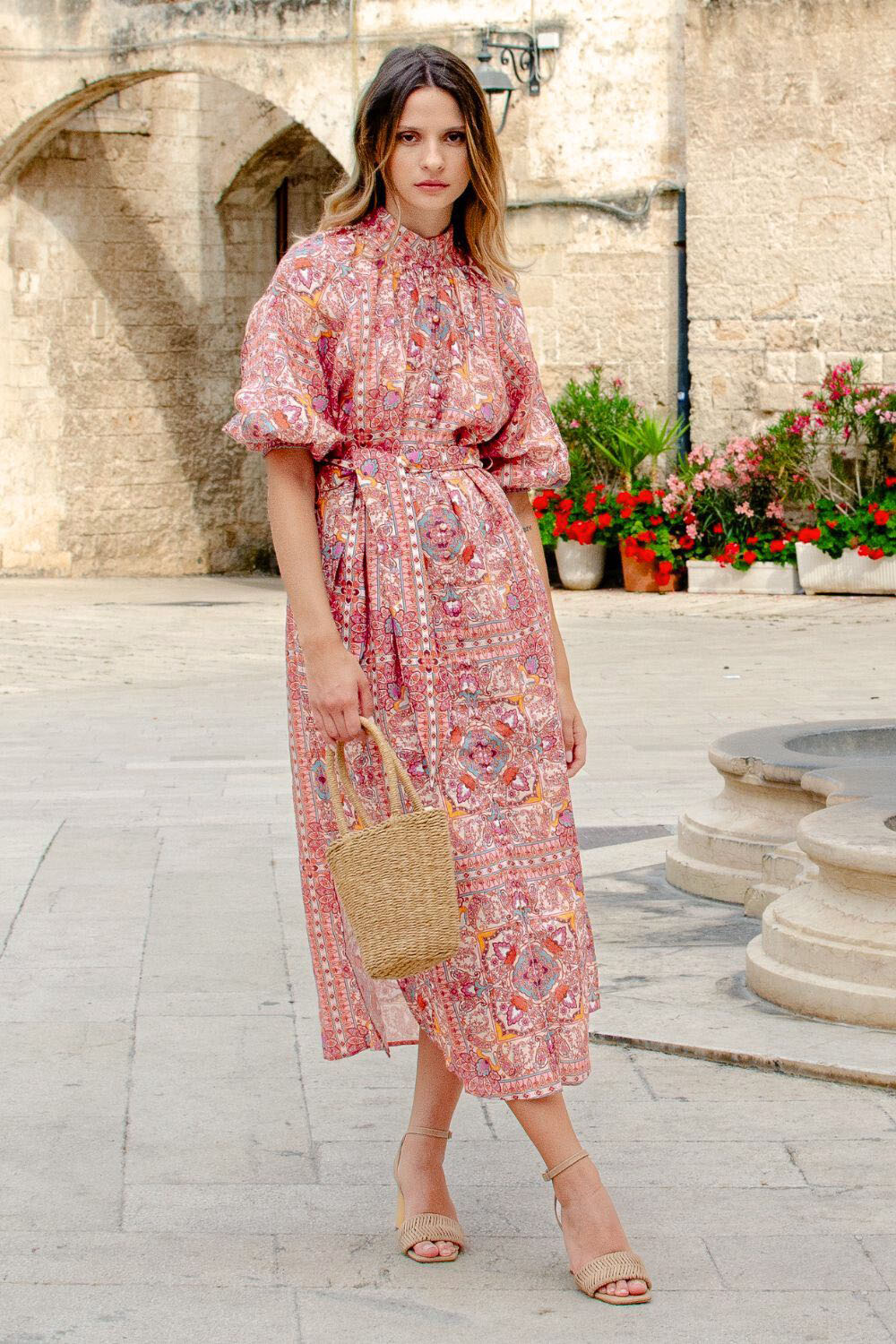 pink print, high neck, covered buttons down centre, self tie fabric belt, elasticated sleeve cuff, mid length sleeve, side splits, midi dress, campaign image