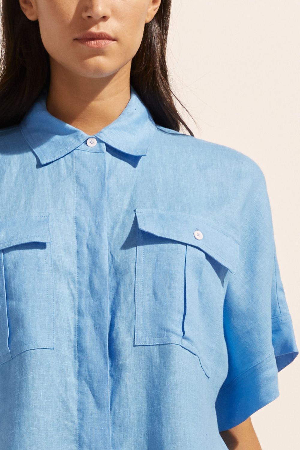 blue, jumpsuit, button down collar, oversized patch pockets, close up view