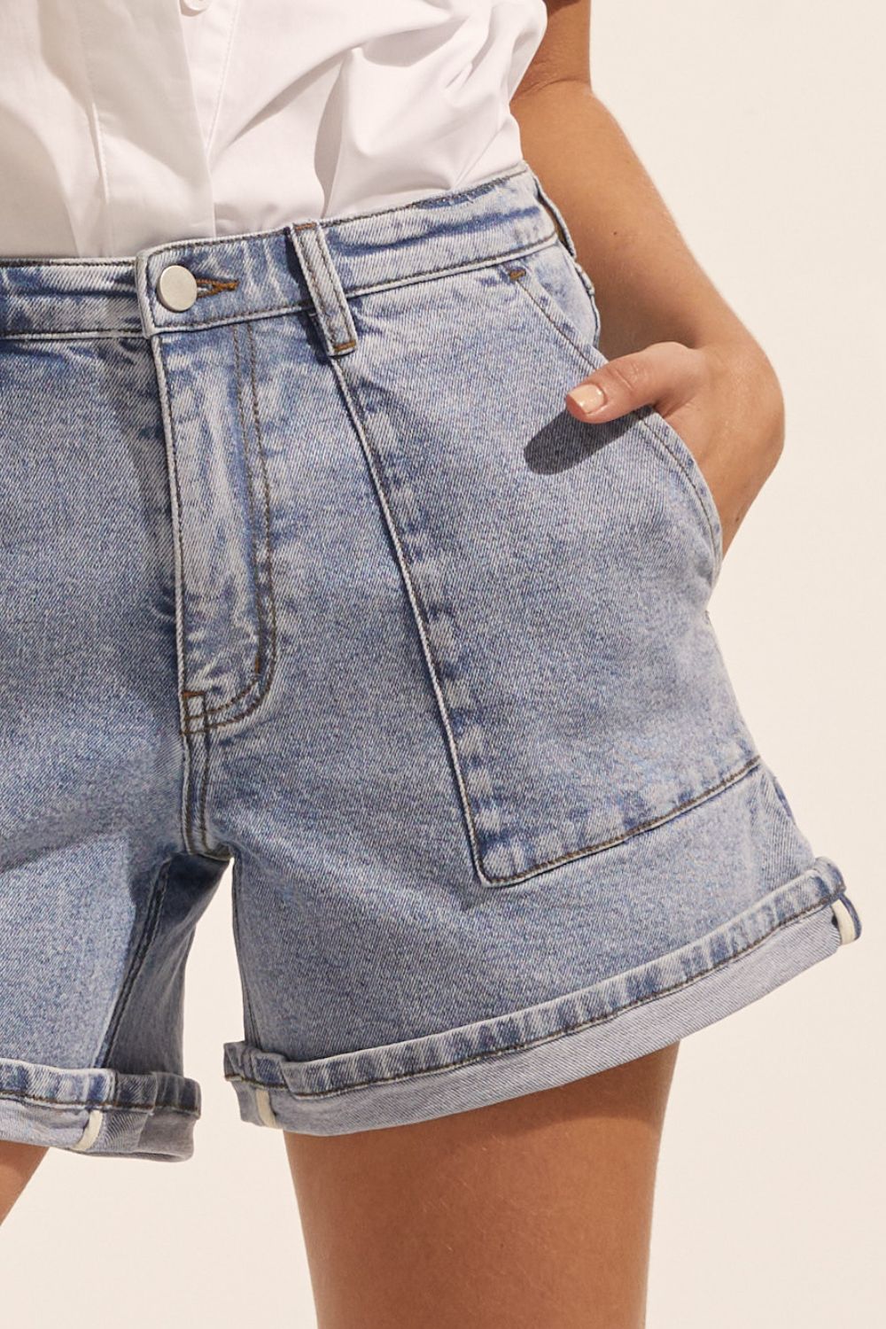 blue denim, shorts, cuffed leg, top stitched pockets, mid rise, close up image