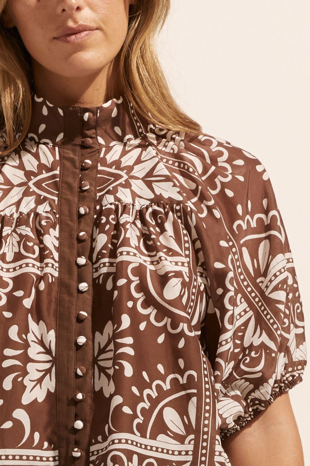brown and white print, top, high neck, button down, mid length sleeve, close up image