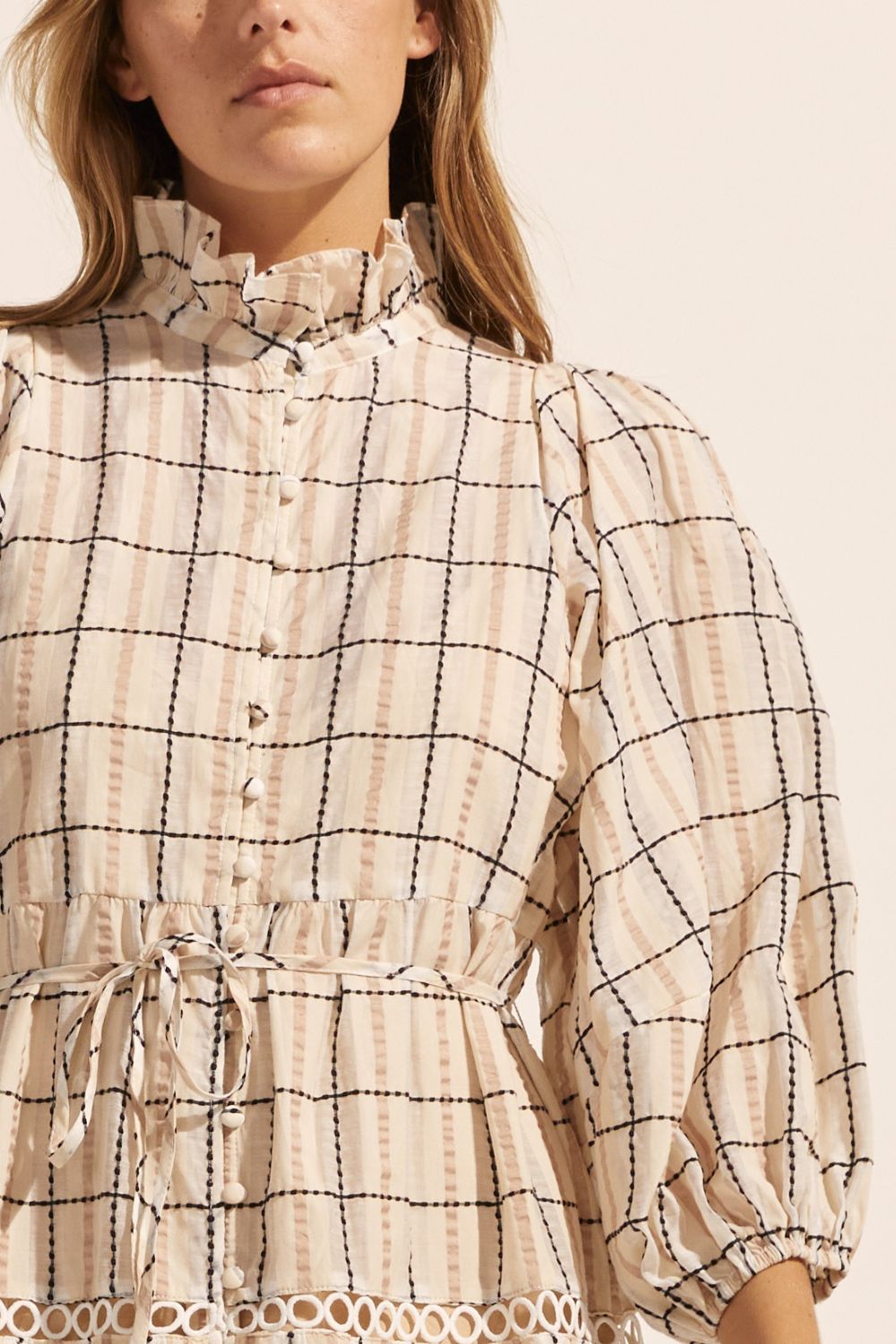 cream check print, dress, buttons through centre, ruffle collar, mid length sleeve, self tie fabric belt, midi dress, tiered skirt, close up image